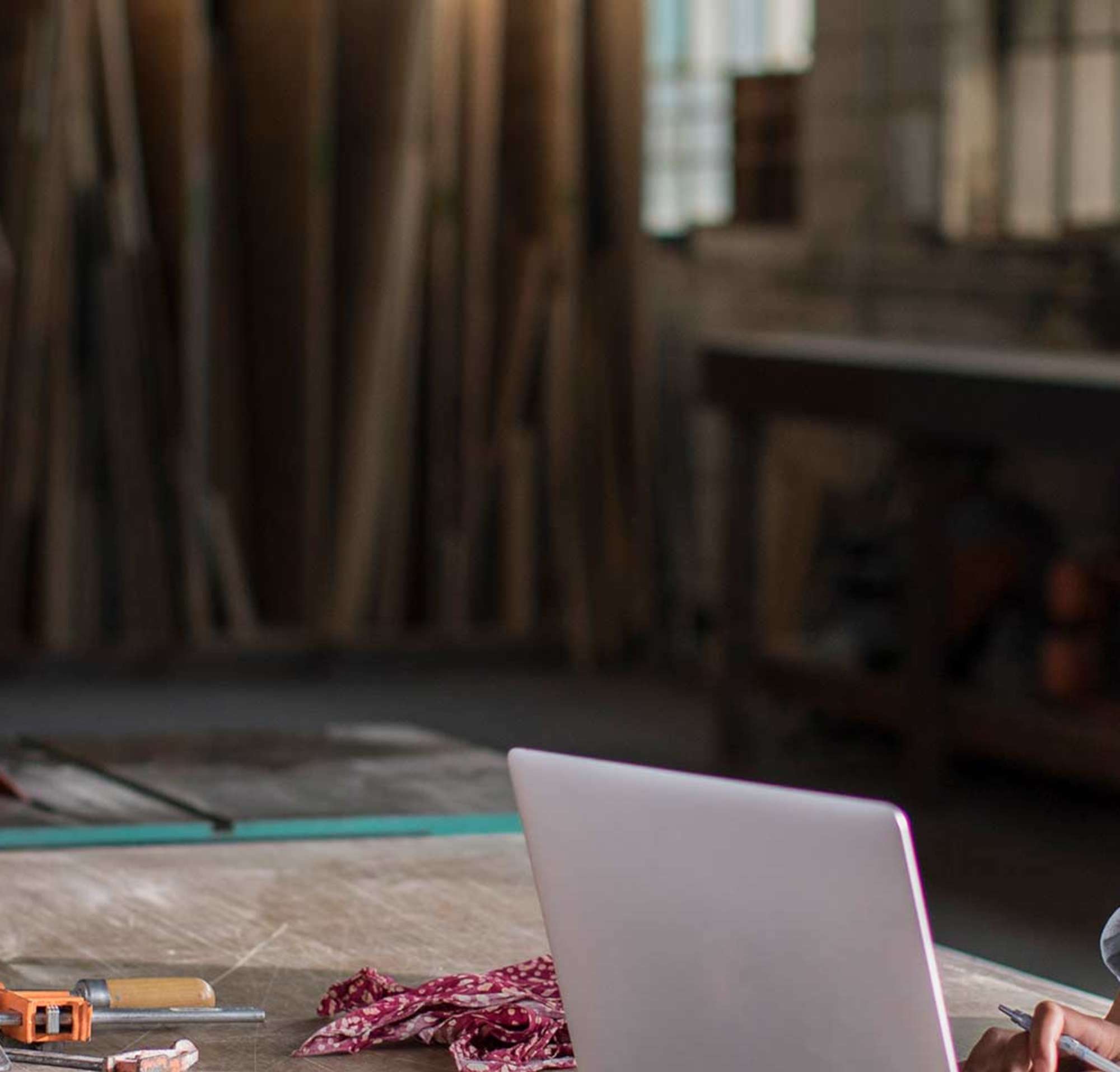 Une jeune femme travaillant sur un ordinateur portable dans son atelier de menuiserie.