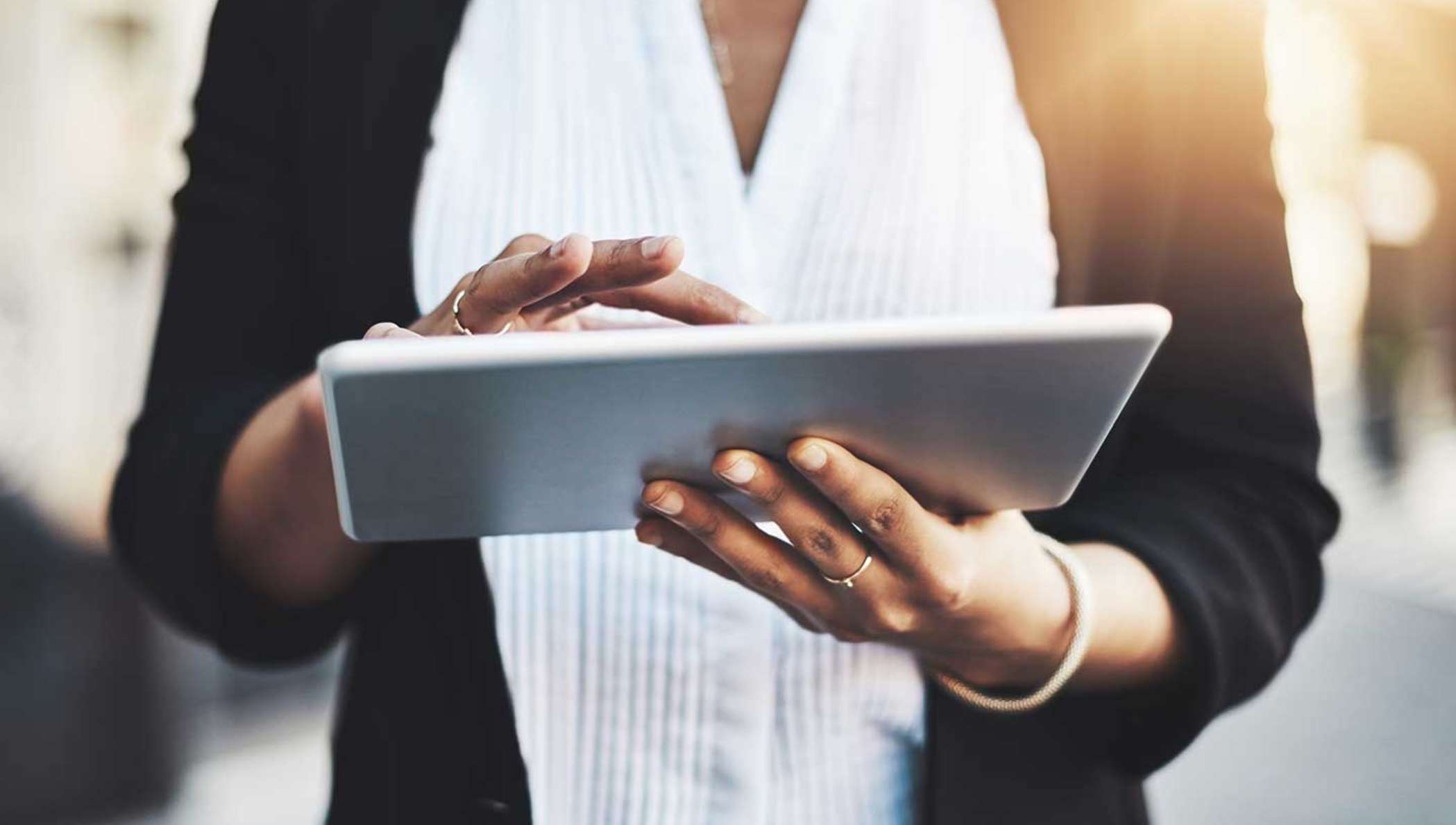 Une femme d'affaires consulte sa tablette pour trouver des informations sur un document à signer.